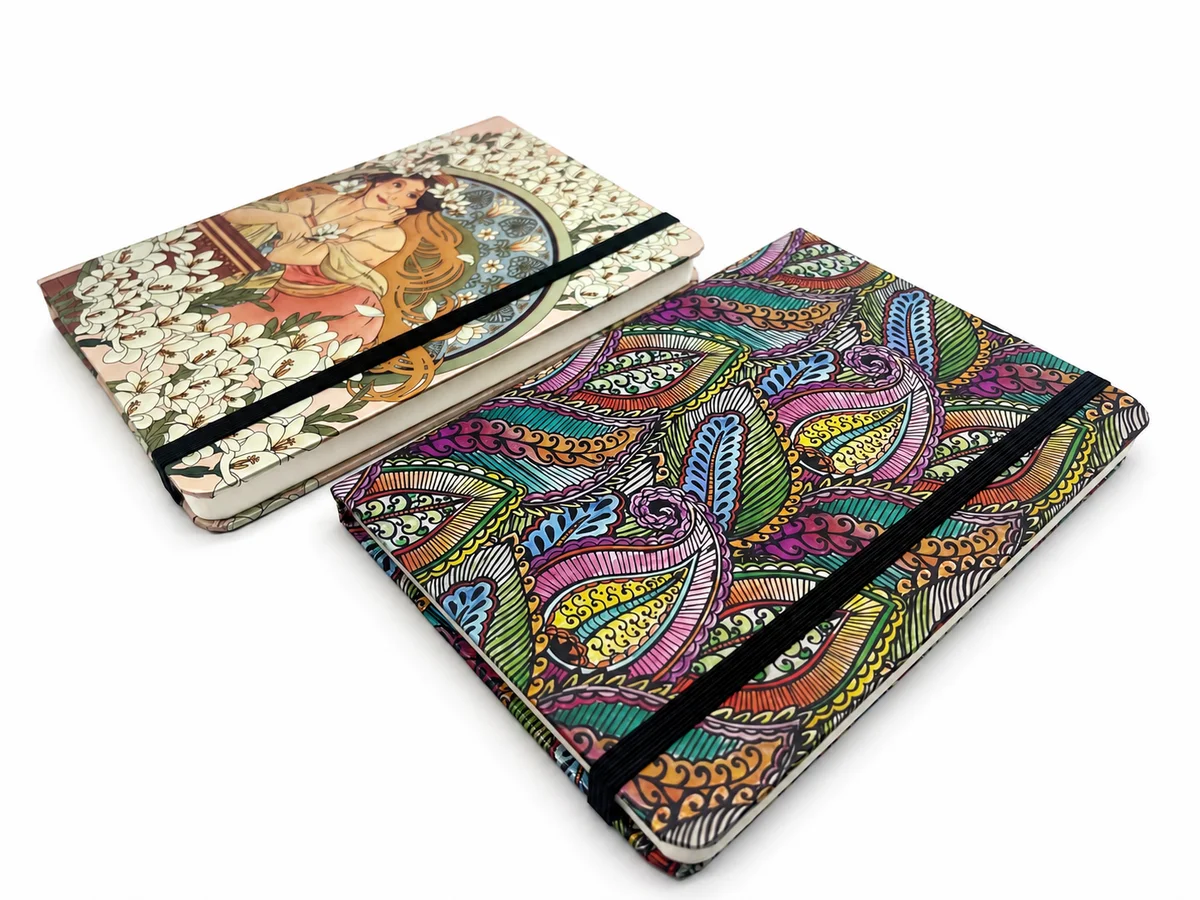 Premium B6 hardcover journal with holographic specialty paper cover, debossed detailing, ribbon marker, and sewn casebound binding.